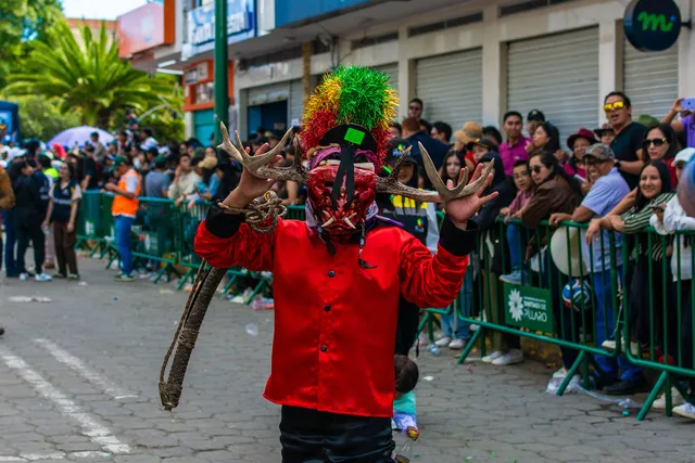 Dancer of the Píllaro diablada adjusting his deer-antler mask