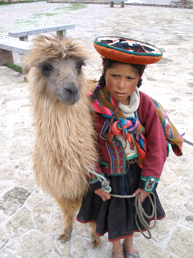 Niña quechua con su llama en el Cusco