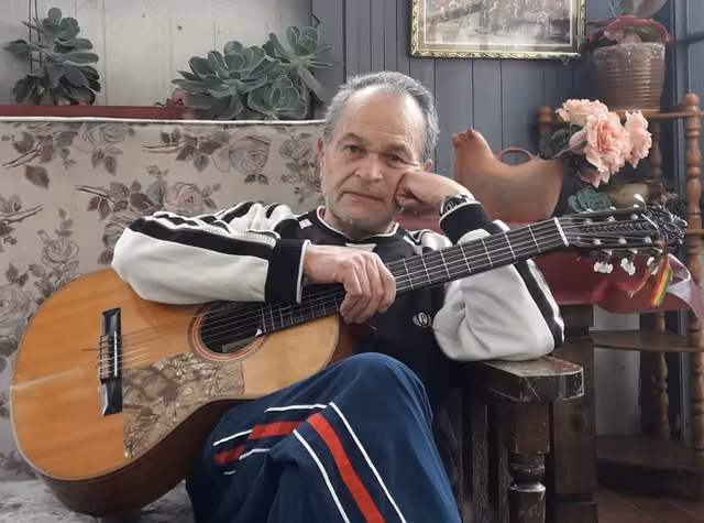 Julio César Paredes posing with his guitar in La Paz