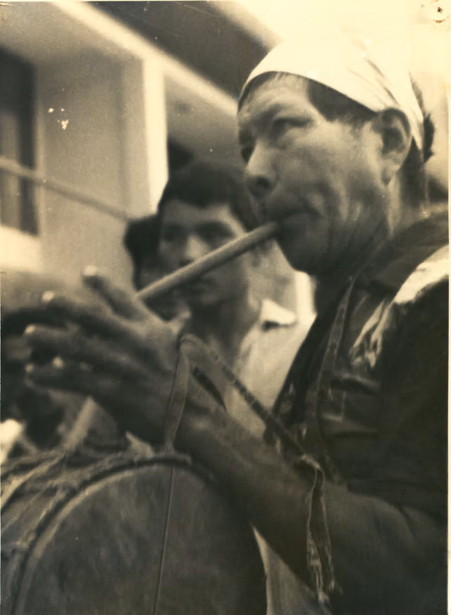 Indigenous man playing quena and drum
