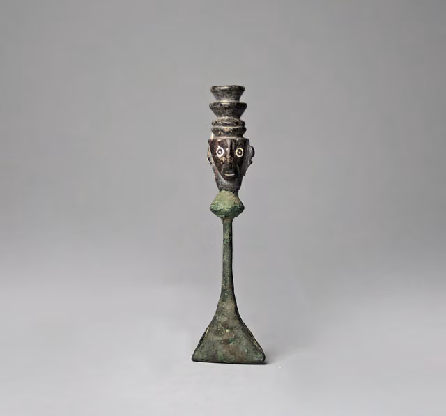 Sonajero de cobre con cabeza de piedra