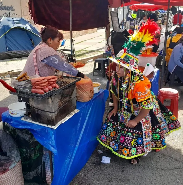 Cochabamba (Bolivia): street food vendor and tinku dancer waiting for a choripan