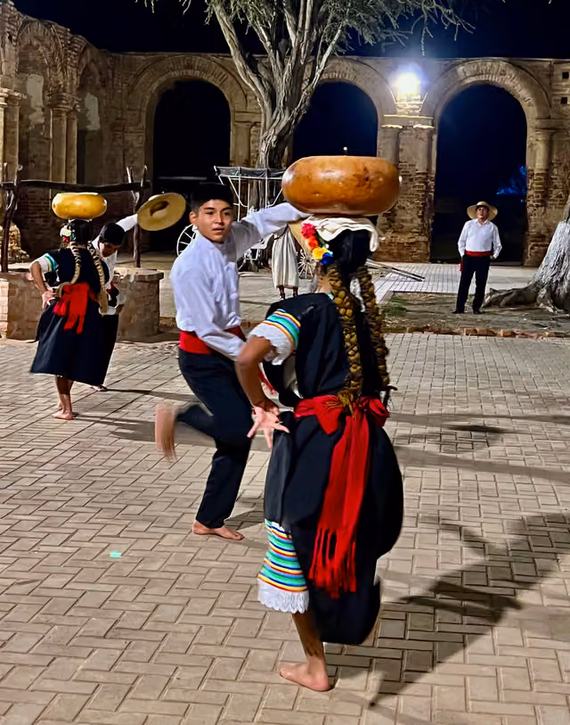 Dancers carrying a carved gourd on their heads (Peru)
