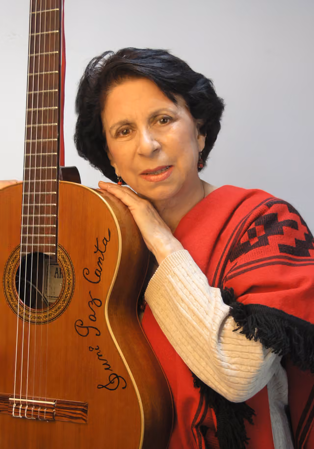 Suni Paz con poncho rojo y guitarra