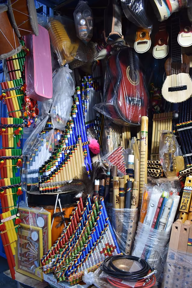 Indigenous musical instruments: quena, tarka, veinte y medio, rainstick, tablasiku and zampoña, with charango and guitar