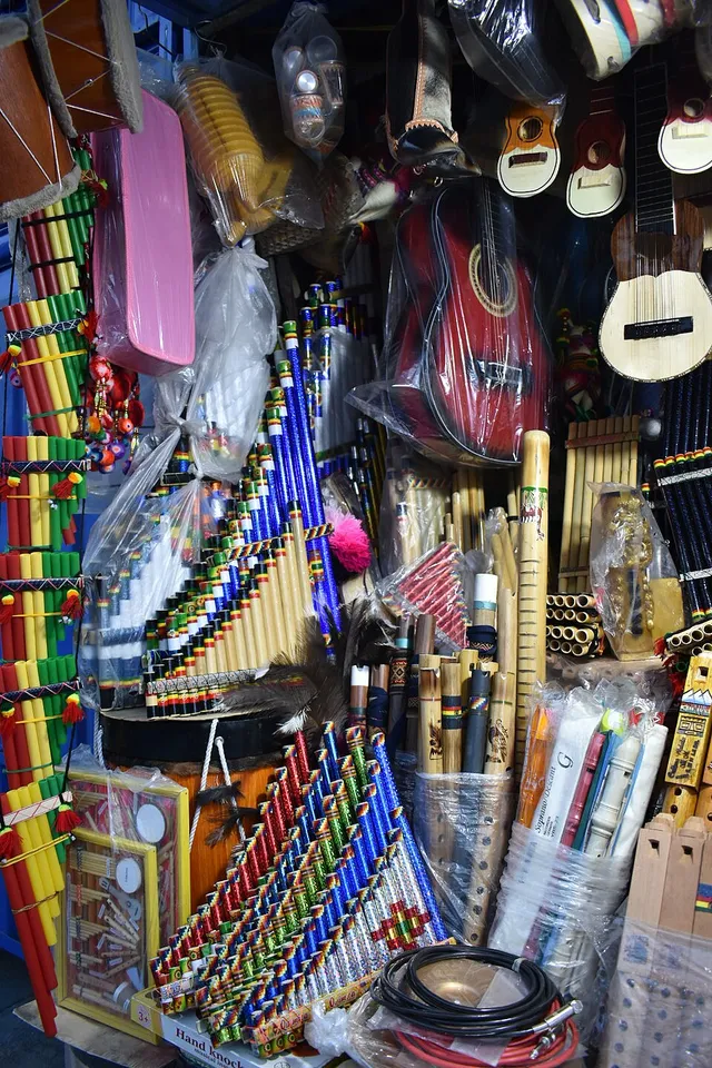 Indigenous musical instruments: quena, tarka, veinte y medio, rainstick, tablasiku and zampoña, with charango and guitar