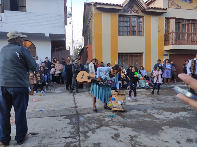 Woman lifts her comparsa's instruments in Villa Rivero