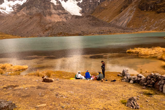 Family at a Peruvian lagoon with the guide to the apu