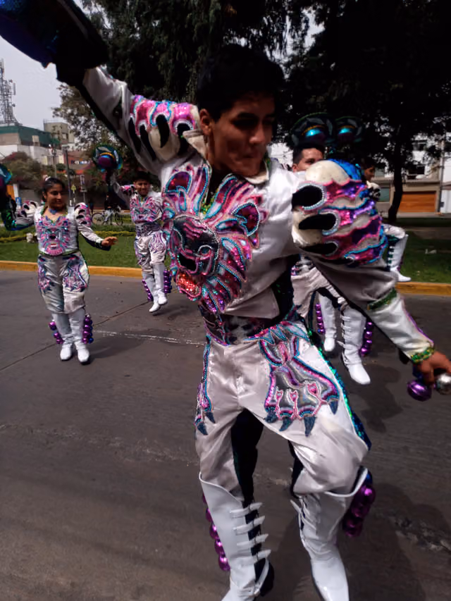 Caporales in a street parade in San Borja